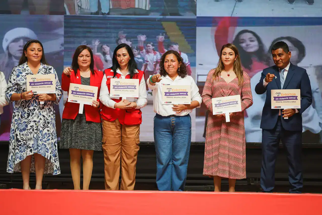 Prevención de la violencia sexual en eventos públicos, mujeres y representantes con carteles que promueven entornos seguros y respeto en Loreto Noticias en Perú.