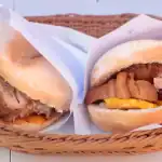 Deliciosos sandwiches tradicionales con carne y pollo presentados en un cesto de mimbre, perfectos para disfrutar en Loreto Noticias y promocionar la gastronomía local.