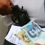 Policía revisa dinero y arma en Loreto, Perú; situación de seguridad y violencia armada en la región.