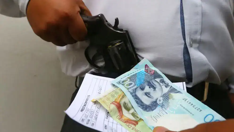 Policía revisa dinero y arma en Loreto, Perú; situación de seguridad y violencia armada en la región.